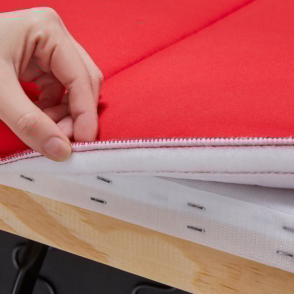 Hand unzips red sofa cushion, shows white interior and stitching.