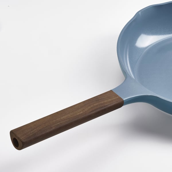 Light blue frying pan with wooden handle, showcasing high-quality design and craftsmanship.