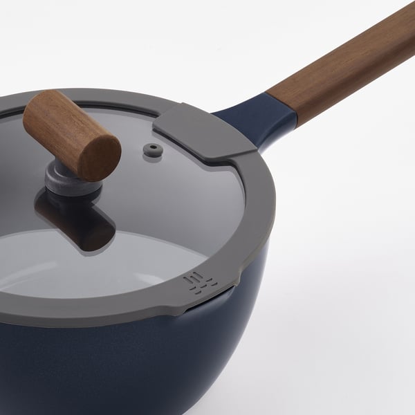 Close-up of modern saucepan with wooden handle, featuring non-stick interior, secure lid, and stylish design.