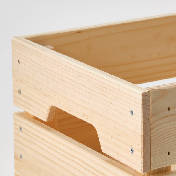 Stacked wooden crates with cut-out handles on bottom, light grey background.