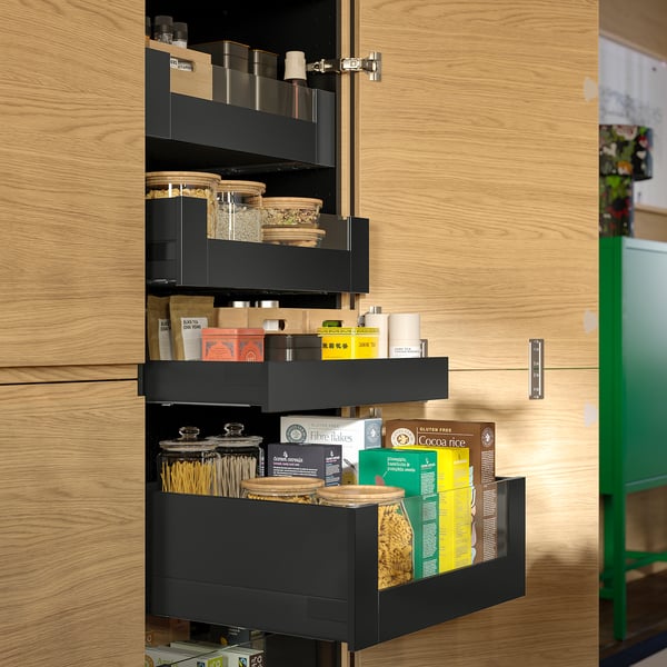 Modern kitchen cabinet with KNIVSHULT drawers storing jars and boxes, showcasing sleek organisation, smooth-closing drawers, and uniform dark design.