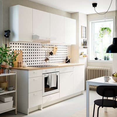 A white KNOXHULT kitchen set with wooden countertop, including cabinets and drawers for storage.