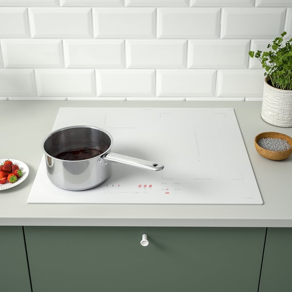 Modern kitchen with KOLSTAN induction cooktop. Strawberries on counter.