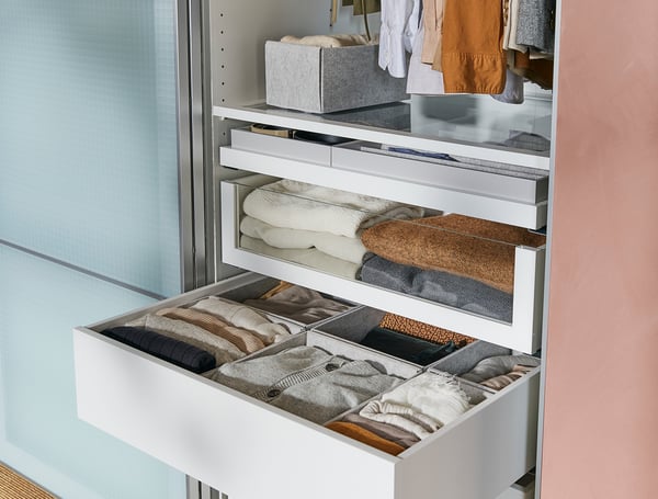 White KOMPLEMENT drawer set with folded clothes, neatly organised in compartments.