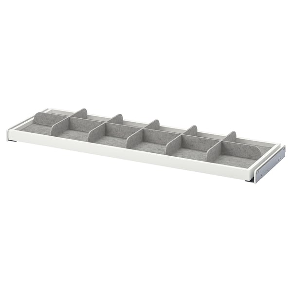 A KOMPLEMENT grey and white drawer divider with multiple compartments for organizing small items.