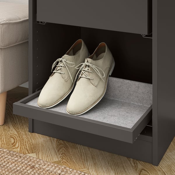 A grey wardrobe compartment with pull-out tray holding beige shoes, showcasing organised storage with rails and non-slip felt.