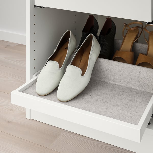 A pull-out shoe tray with light grey felt lining, holding multiple pairs of shoes, showcasing a tidy storage system.