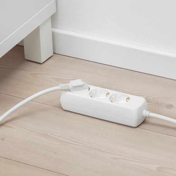 White extension cord on floor, offers 3 extra sockets with safety shutters, 1. 5m cable.