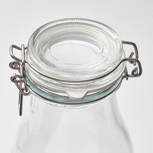 A clear glass jar with a secure metal clamp and rubber seal, ideal for preserving and storing food.