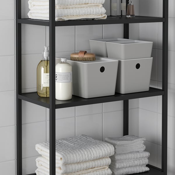 A organiser with bottles and towels. The white bins keep items neat and accessible on bathroom shelves.