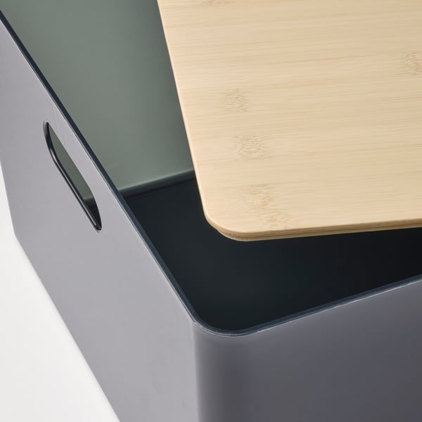 Close-up of a modern, high-quality bamboo lid on a grey box, showcasing natural, durable design.