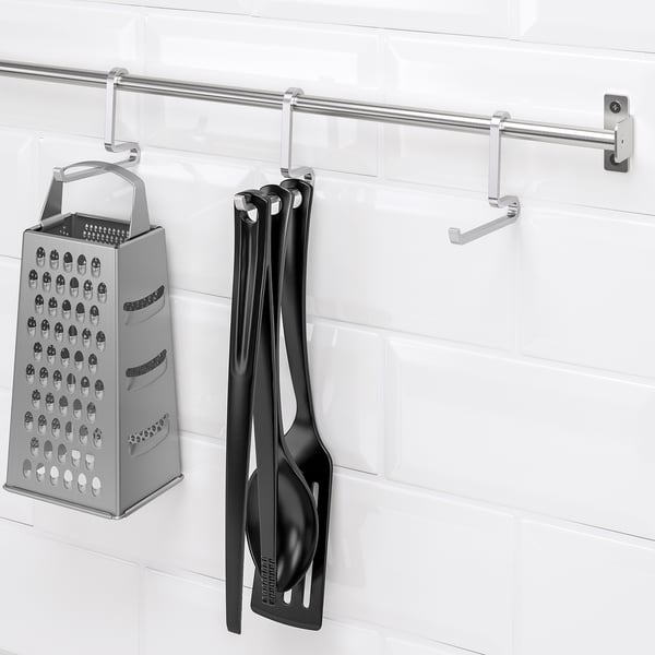 Silver rail with hooks; hangs cheese grater and black utensils.