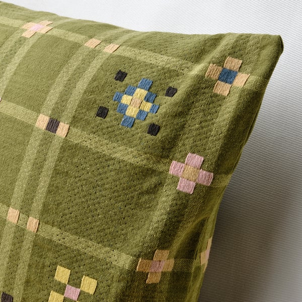 Close-up of a KUSTGRAN cushion cover in yellow-green, showcasing its detailed, woven monks belt pattern and high-quality cotton texture.