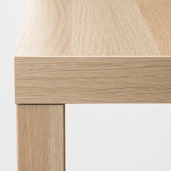 A high-quality close-up of a wooden tables edge, showing smooth, light-colored wood with a clean and sleek finish.