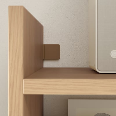 Wooden shelf bracket in light brown. Attached to wall and shelf, showing corner detail.