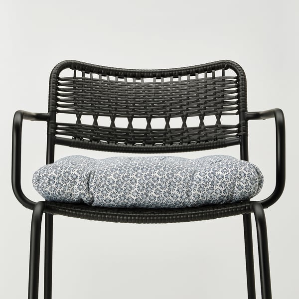 Black wicker chair with patterned cushion, stylish and durable outdoor seating.