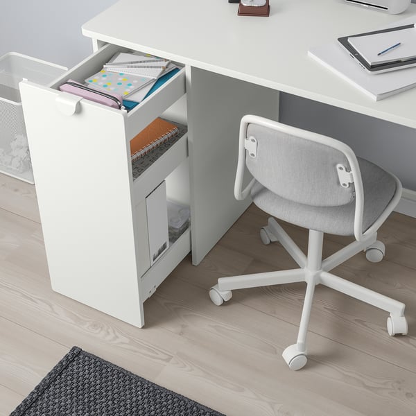 A white desk with a pull-out storage unit filled with books and folders.
