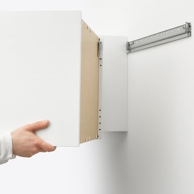 Hand opens white LÄTTHET storage unit, revealing internal compartments and hooks, highlighting its external storage functionality.