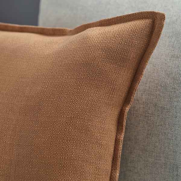 Close-up of brown cushion cover with zip and textured surface.