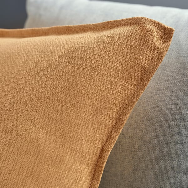 A close-up of a textured, yellow-beige cushion cover with clean stitching and edge.