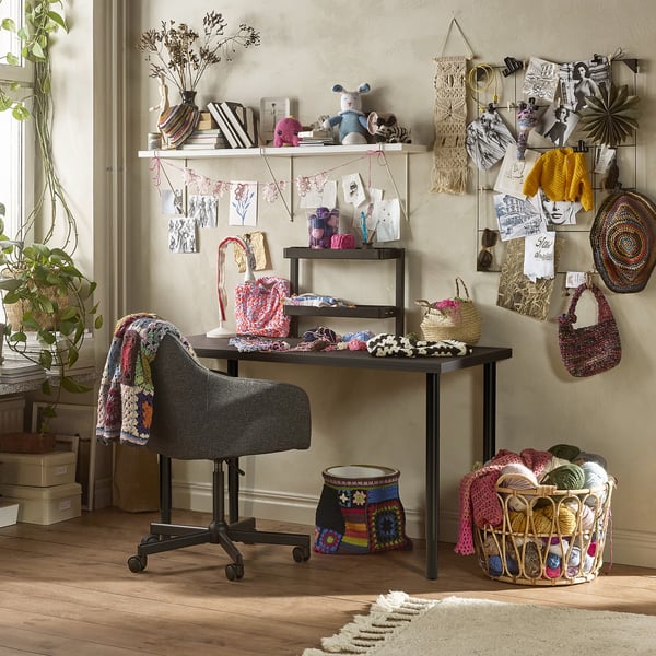 Creative craft workspace featuring LAGKAPTEN desk with colourful accessories, yarn, and crochet items.