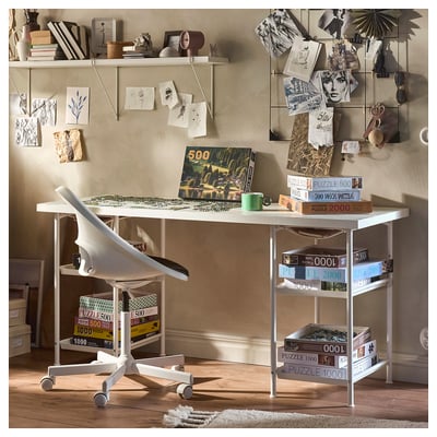 Modern workspace with white LAGKAPTEN table, jigsaw puzzles, white chair, and decorated wall.