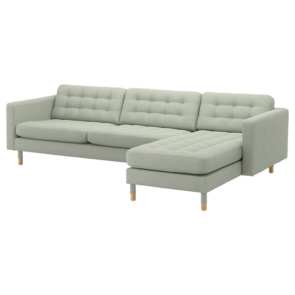 Light gray modular sofa with tufted back and seat cushions, wooden legs, l-shape.
