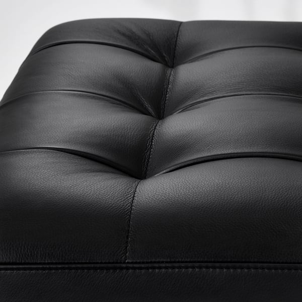 Black leather furniture close-up showing smooth, stitching detail, and textured finish.