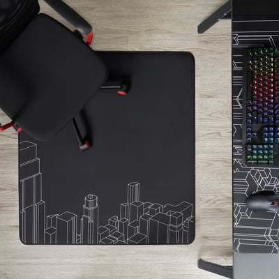 Three-legged black chair on an abstract cityscape floor mat beside a colourful keyboard.