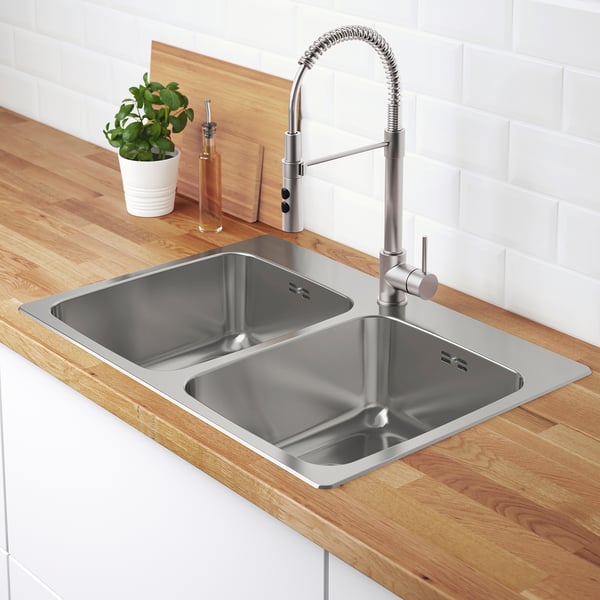 Stainless steel double sink with sleek tap and modern countertop.
