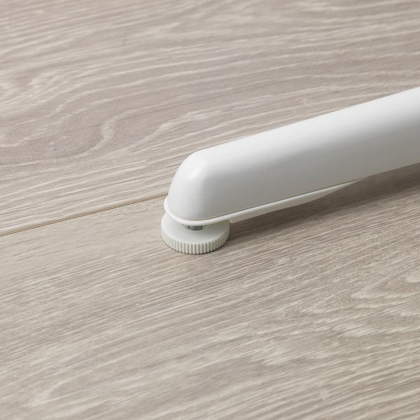 White junior chair footrest on wood floor. Adjusts for stability.