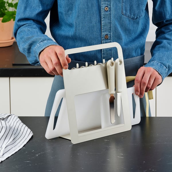 Person holding a LEGITIM chopping board with knives. Utility and serving function shown.