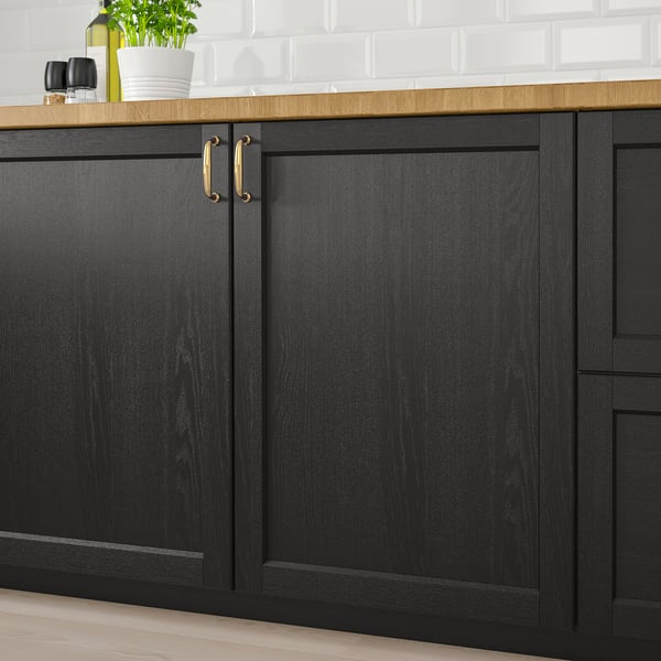 Black wooden kitchen cabinets with gold handles. Part of the LERHYTTAN series, adding a rustic charm to the kitchen.
