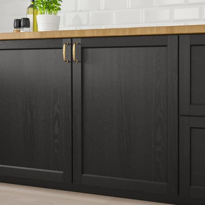 Black wooden kitchen cabinets with gold handles. Part of the LERHYTTAN series, adding a rustic charm to the kitchen.