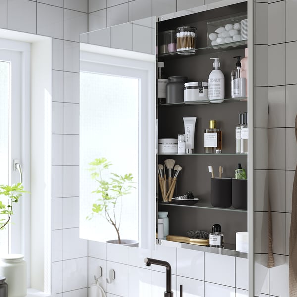 Mirrored bathroom cabinet for toiletries and cosmetics, enhancing light and space.