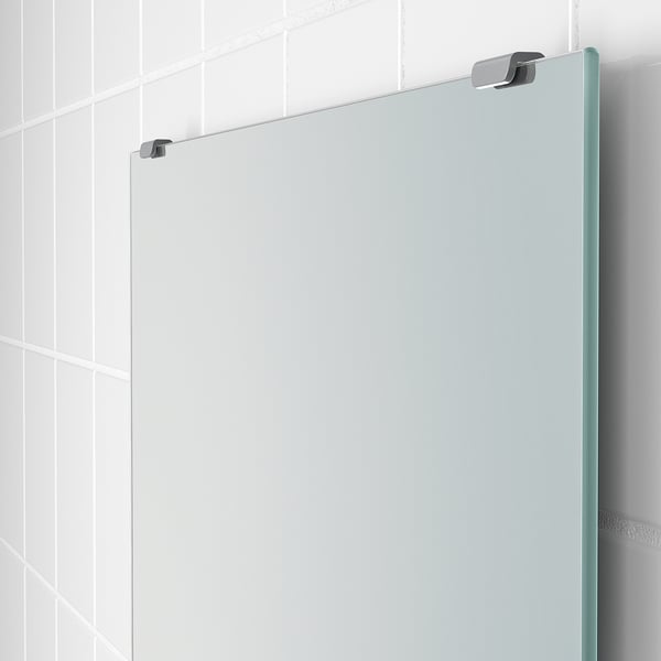 Modern bathroom with frameless, adjustable mirror.