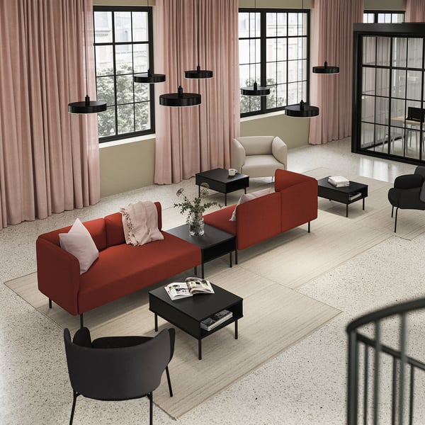 Modern living room with LILLEHEM orange sofa, black armchairs, circular pendant lights, and large windows with pink curtains.