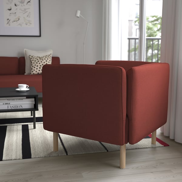 Two red upholstered chairs with wooden legs facing a window in a modern living room.