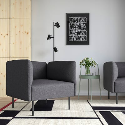 Modern living room with LILLEHEM grey fabric sofa, small green side table, and geometric rug. Art print hangs above.