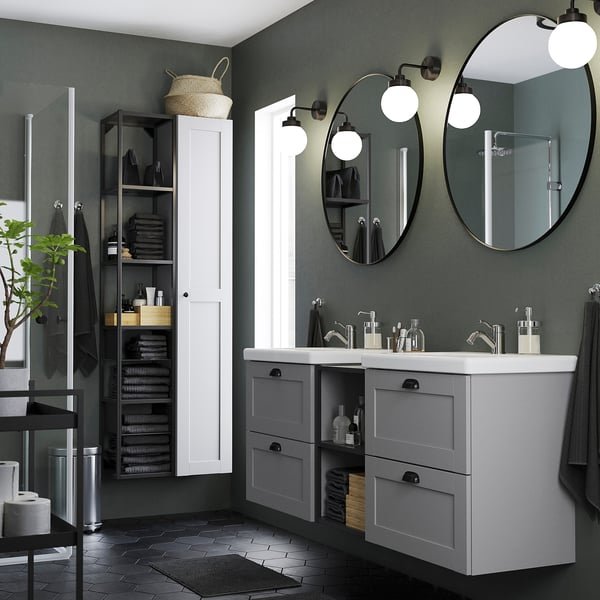 Modern bathroom with black round mirrors, grey cabinets, white countertop, safety film.