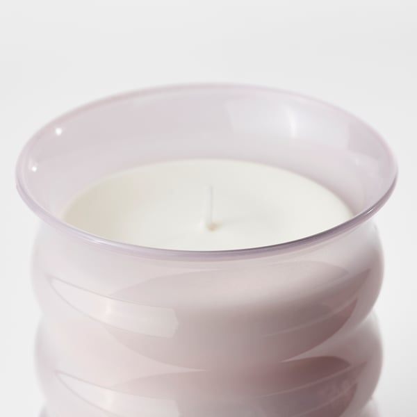 Clear glass candle jar with light pink tint, holding a single unlit white candle with a cotton wick. Elegant, high-quality design.