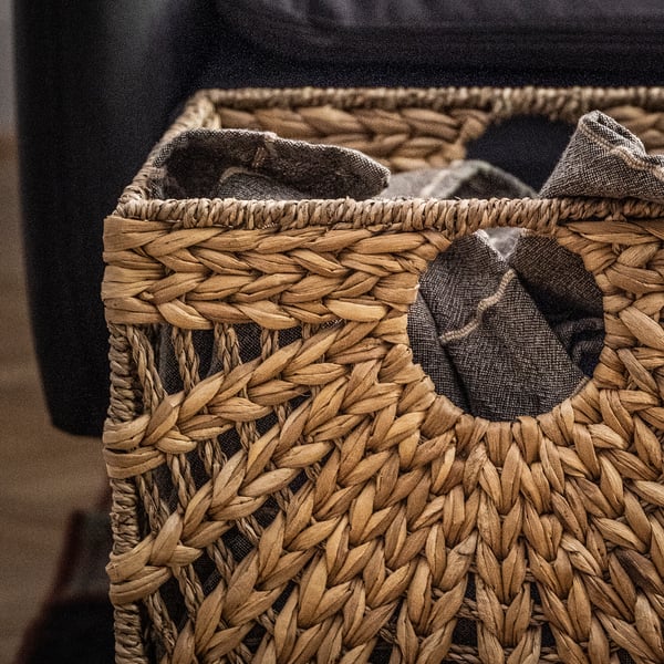 Wicker basket, brown, rectangular, filled with dark grey items.