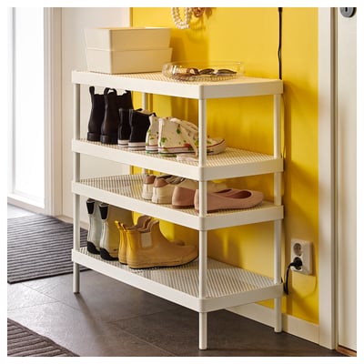 MACKAPÄR shoe rack with boots, sandals, boxes, and dish on yellow wall.