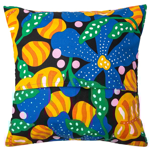 MÄVINN pillow cover: black with large, colourful flowers, green leaves, dots, and striped patterns. Soft cotton squares with envelope closure.