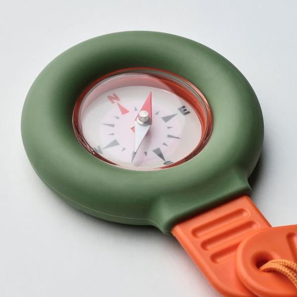 Green compass with orange strap on white background. Clear lens, precise markings.