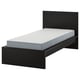 Minimalist black single bed with white mattress, wooden frame, high headboard, modern design.