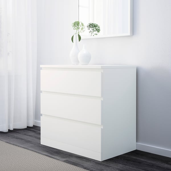 A sleek white chest of 3 drawers serving as a bedside table, offering generous storage with smooth-running drawers for neat organisation.