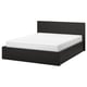 Black wooden bed with white mattress, modern design.