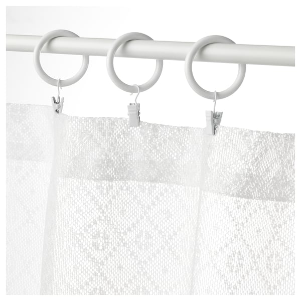 White marilela curtains with a circular metal rod and clips.