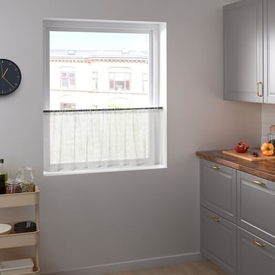 Modern kitchen with sheer white MARIELENA curtains, gray cabinets, kitchen trolley, and clock.